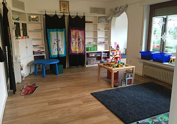 Zimmer mit Spielsachen, an der Wand Regale mit weiteren Spielutensilien